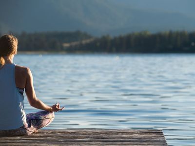 Woman by lake meditating